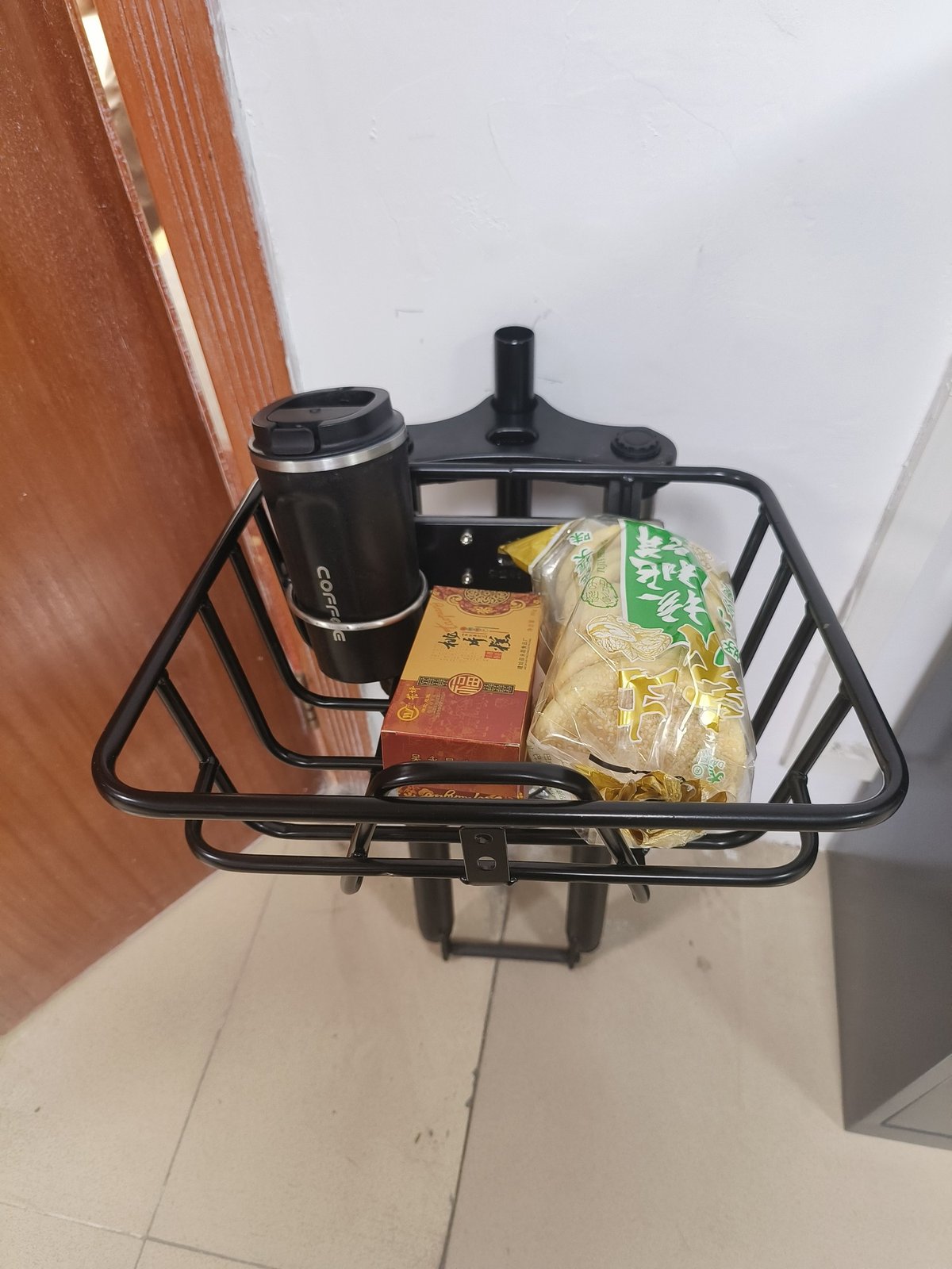 Fabricación de canastas para bicicleta: una canasta para bicicleta montada en la horquilla delantera, con el soporte de montaje apretado en la corona de la horquilla.