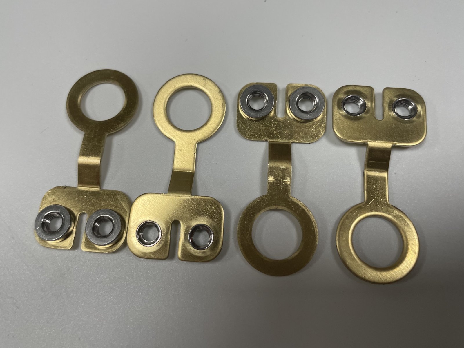 brass battery lugs - The two-hole pad and the round eye, shown with and without assembly screws.