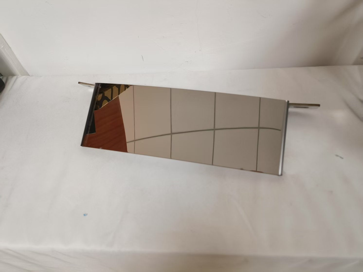 sheet metal capabilities - A mirror-polished stainless steel section, polished to an 8K finish with the brushed grain kept running in one direction.