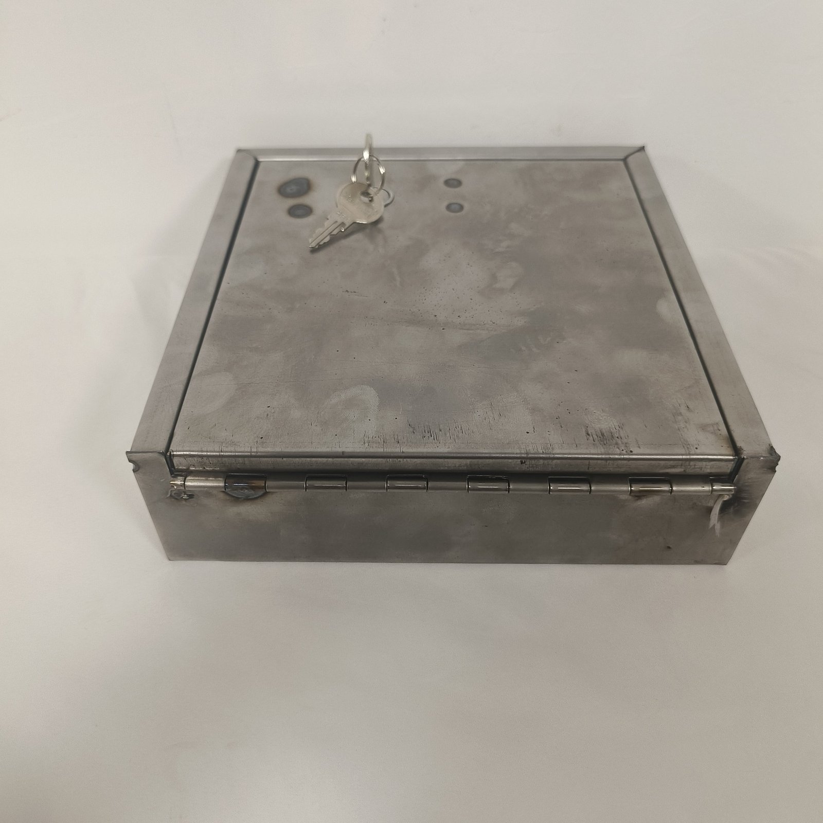 stainless steel letterbox - The door open, showing the hinge, the lock body and the fixing points inside.