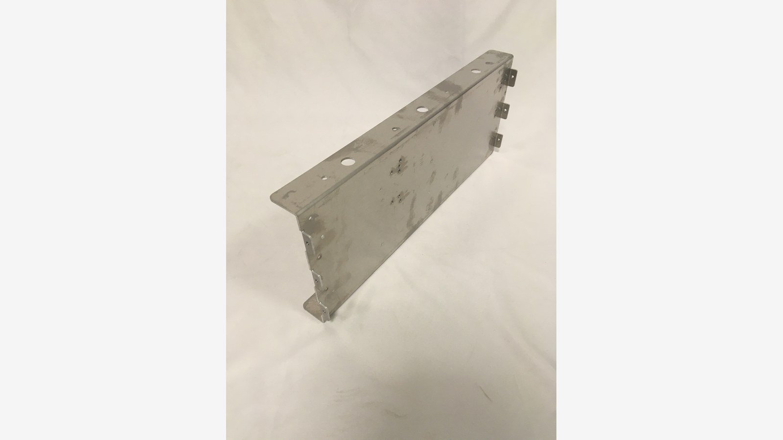 cnc punching service - A punched sheet metal panel with mounting holes, slots and formed edge tabs after punching.